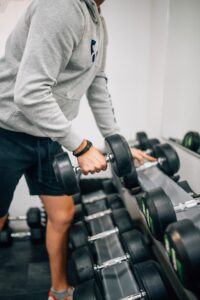 A man lifting dumbbells during a strength workout in a gym