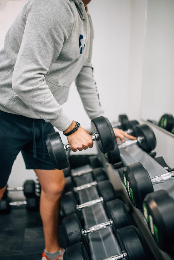 A man lifting dumbbells during a strength workout in a gym